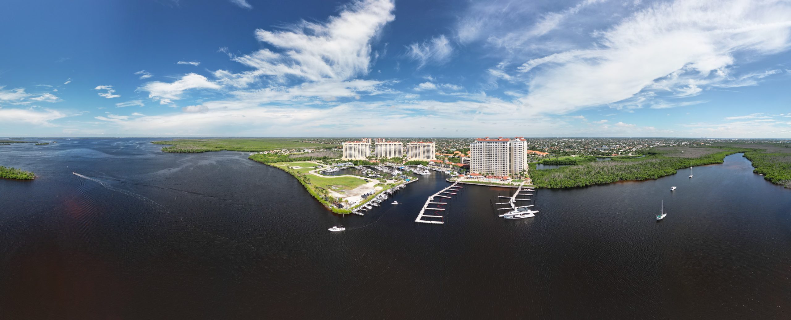 Aerial view of Cape Coral canals at sunset with boats and palm-lined streets